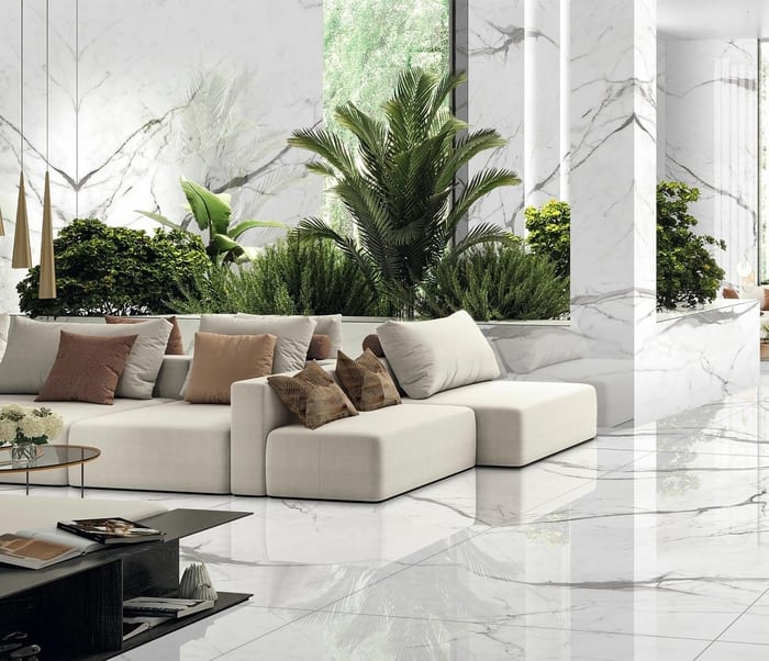 Sala con muro de porcelanato Statuario blanco y vegetación interior