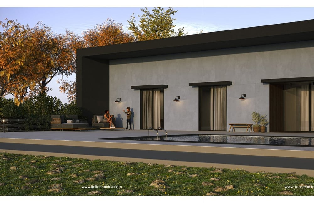 Fachada residencial en porcelanato de gran formato iluminada de noche